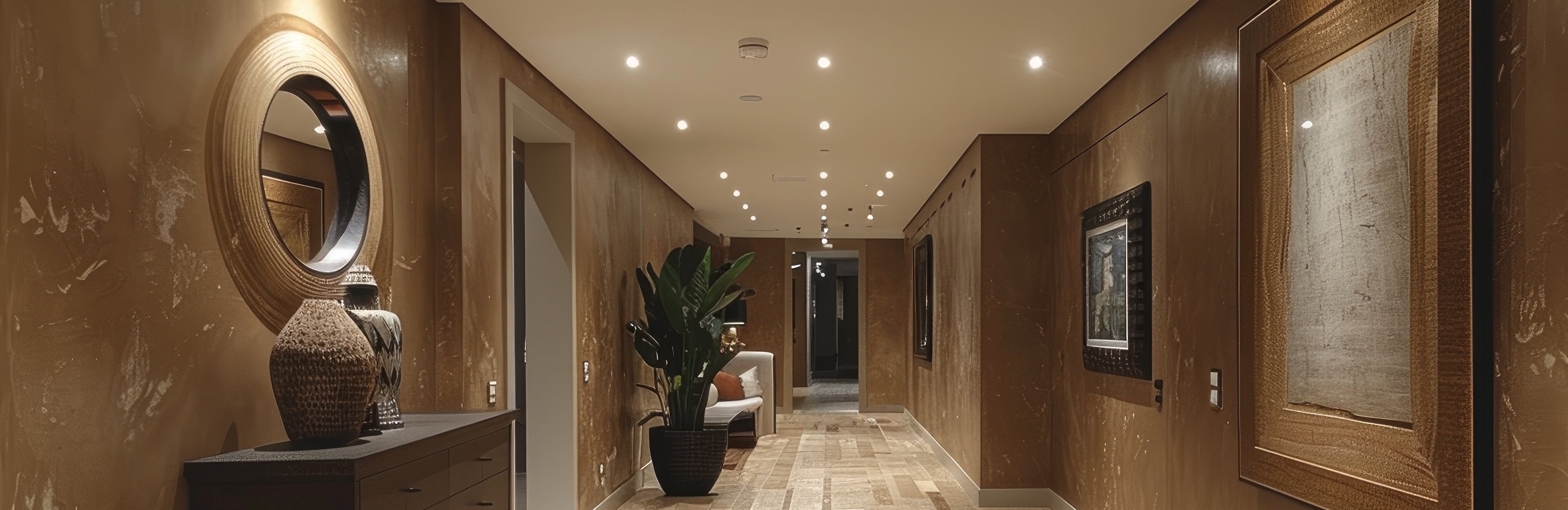 Luxury hotel interior corridor with textured walls, curated art, and ambient architectural lighting creating a refined arrival experience.