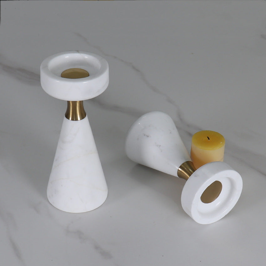 Close up of a marble candle holder lying on its side showing the solid stone base and brass insert