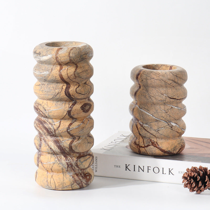 Pair of different sized natural marble vases with wavy ribbed silhouettes and dark brown veining