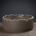 Dark bronze bark-textured ceramic planter with deep vertical ridges and jagged rim