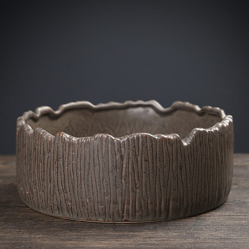 Dark bronze bark-textured ceramic planter with deep vertical ridges and jagged rim