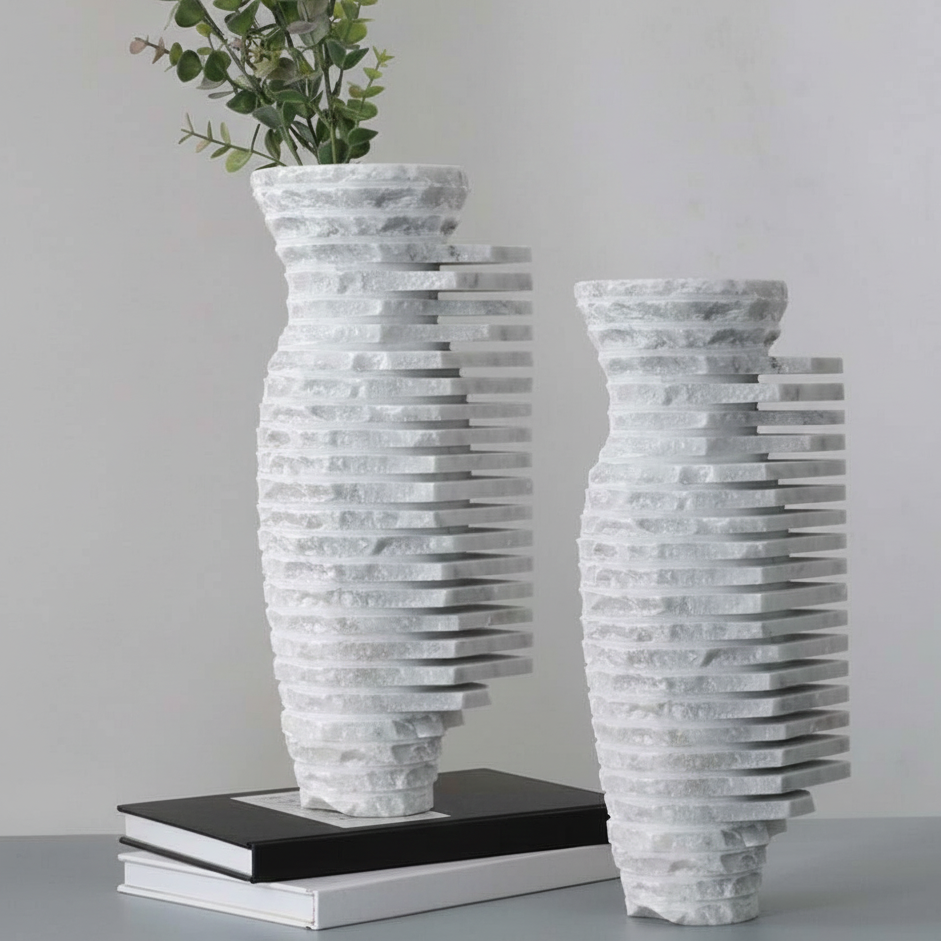 Studio product shot of an abstract white marble vase featuring hand-carved horizontal ridges and a raw stone texture