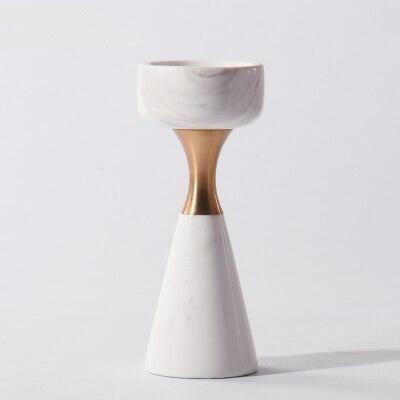 Front view of a single white marble and brass sculptural candle holder against a plain white background