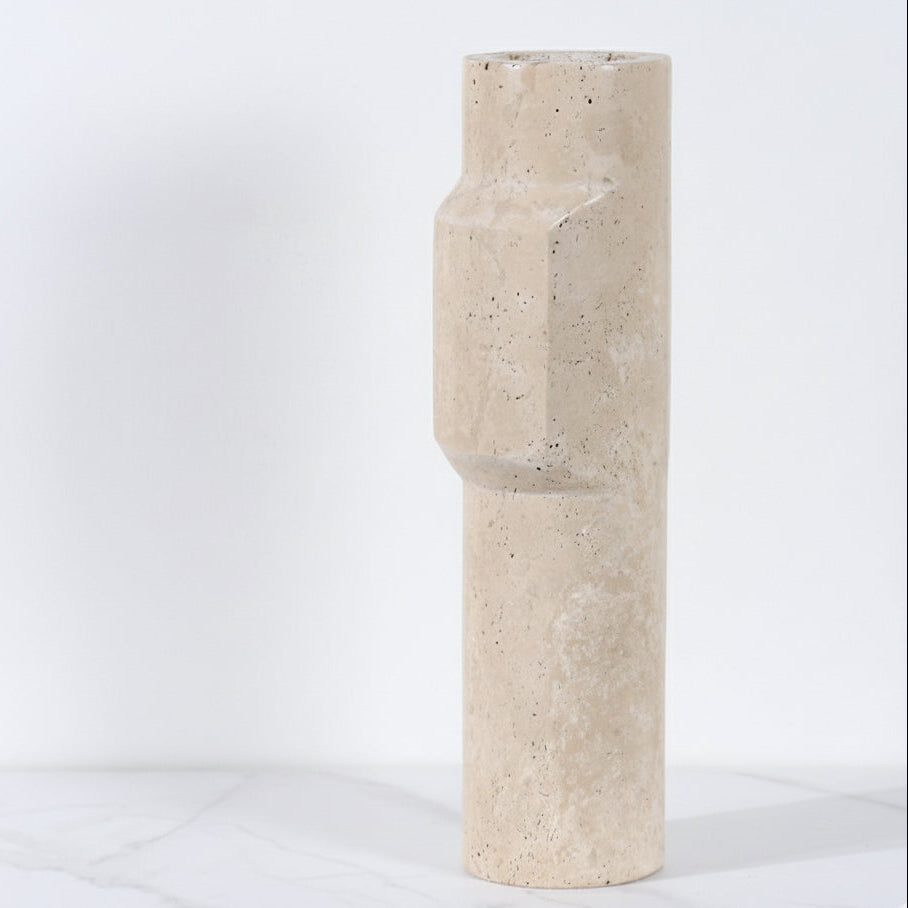 Side view of a tall cylindrical travertine stone vase showing the unique geometric protrusion and porous stone texture