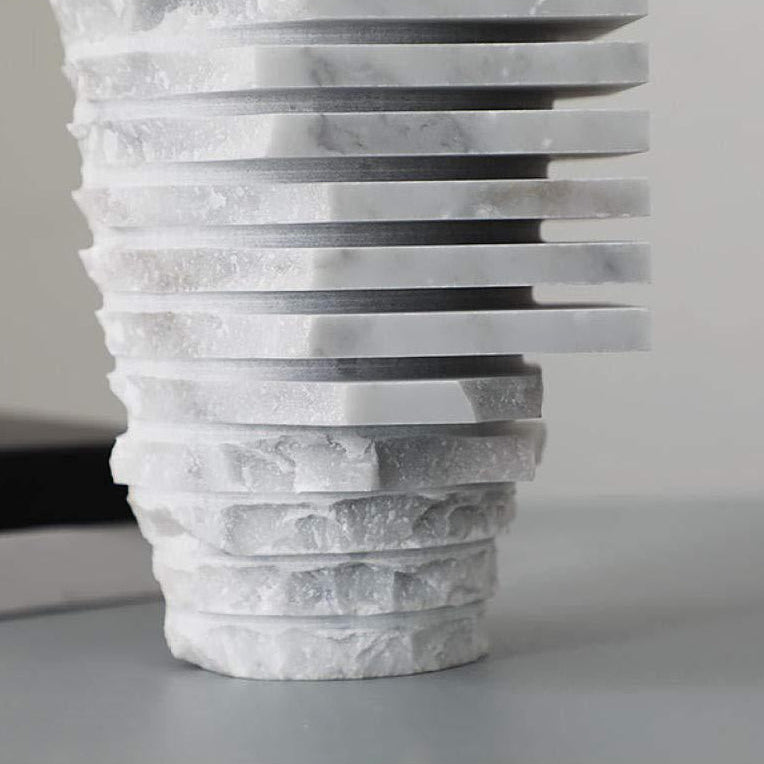 Macro close-up of the raw, chiseled edges and natural grey veining of the handcrafted white marble layers