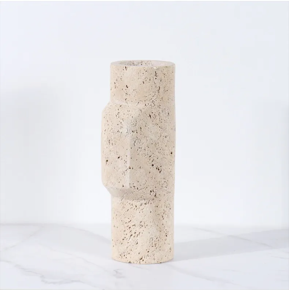 A medium height cylindrical vase made of natural beige travertine stone with a sculptural geometric form
