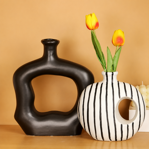Matte black and striped abstract ceramic vases styled on warm neutral background