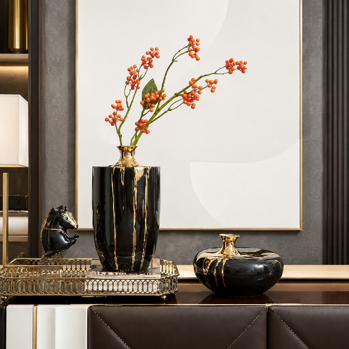 Black and gold ceramic short and tall vase set displayed on modern console table with decorative tray