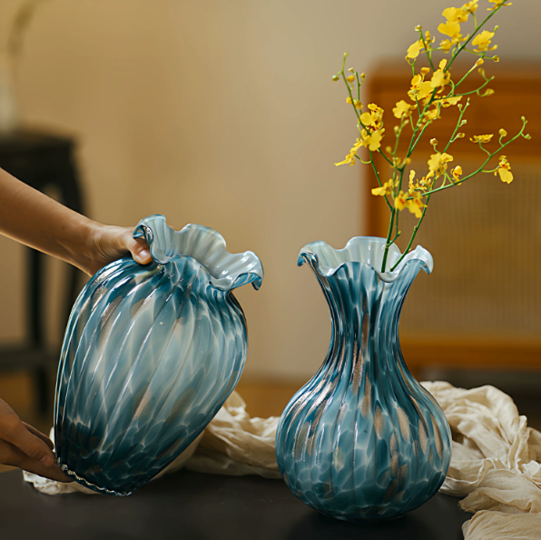 Blue art glass vases styled with yellow flowers and decorative branches