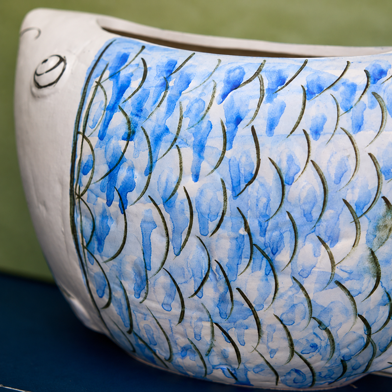 Close-up of blue scale pattern on blue and white ceramic fish vase