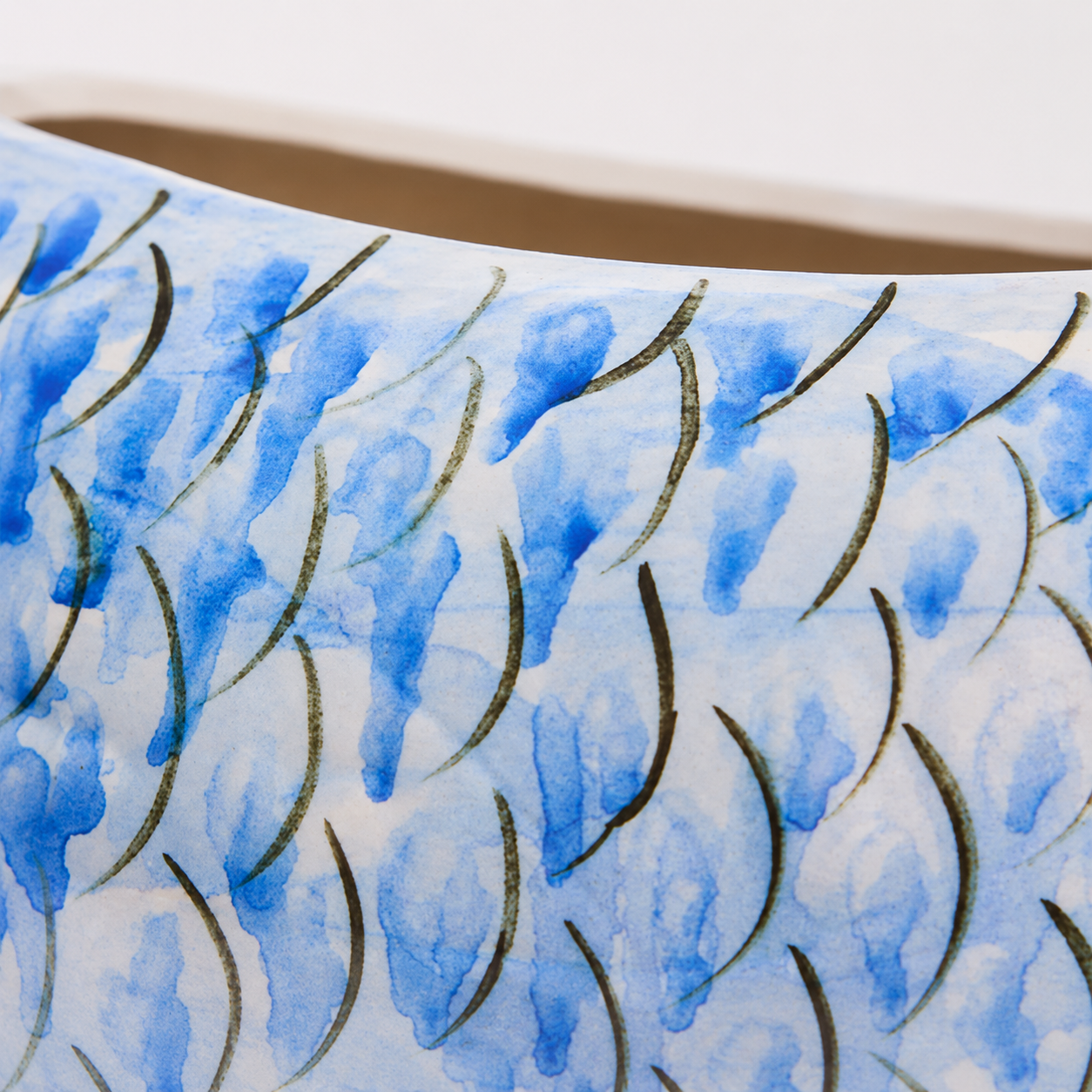 Close-up detail of painted blue scale pattern on ceramic fish vase
