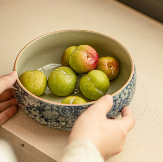 Blue and white floral ceramic serving bowl holding fruit on tabletop
