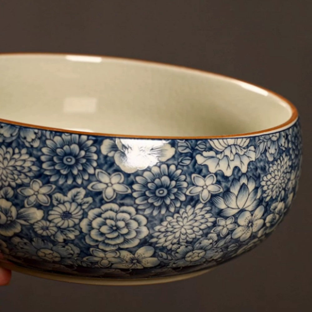 Close-up side view of blue floral ceramic serving bowl with rounded rim