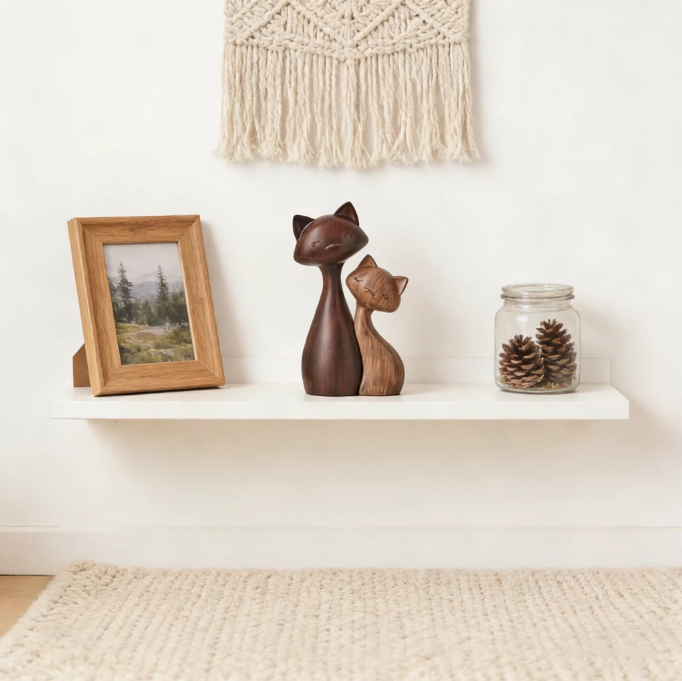 Wood-look cat couple figurine displayed on minimalist shelf with photo frame