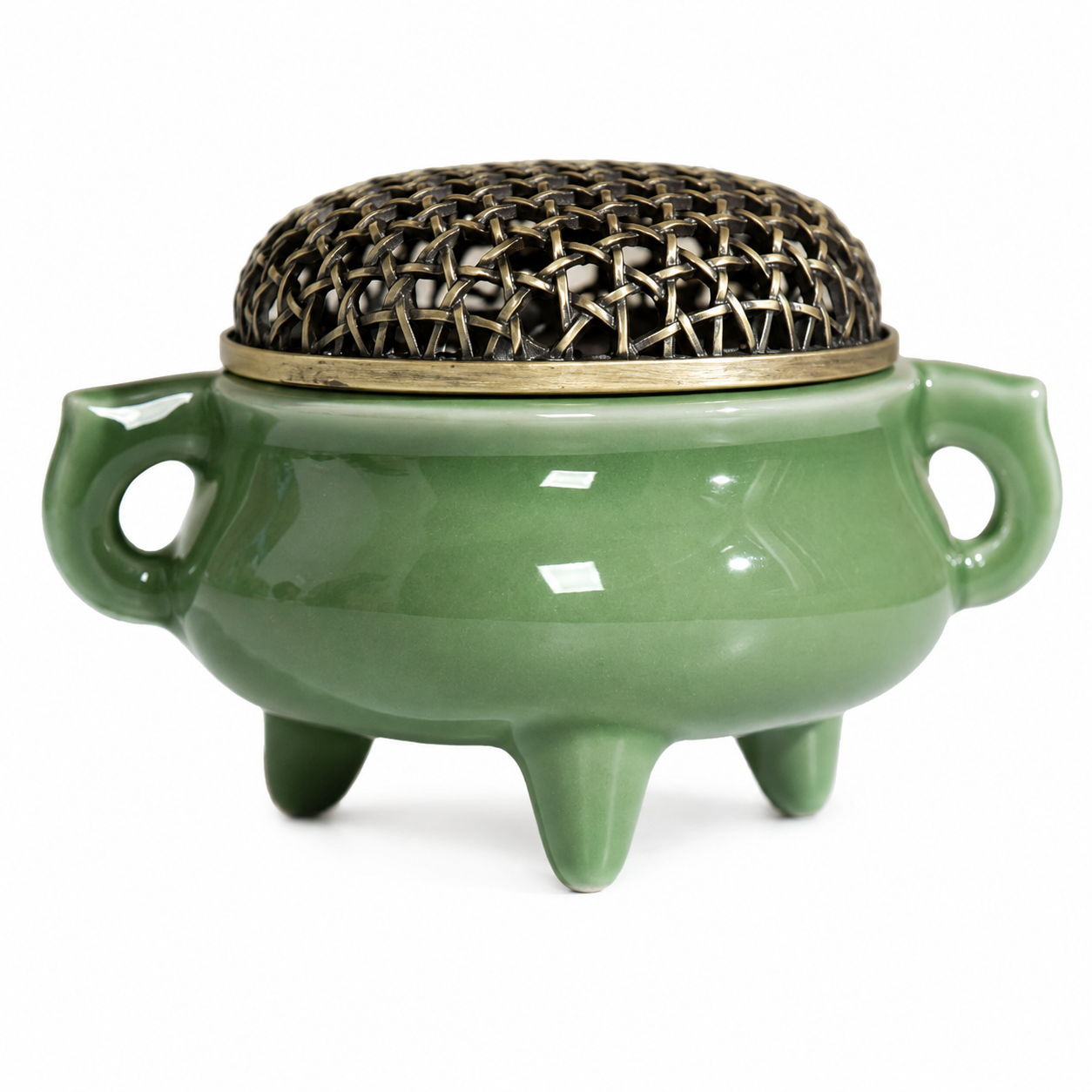 Celadon green ceramic incense burner with brass mesh lid and side handles on white background