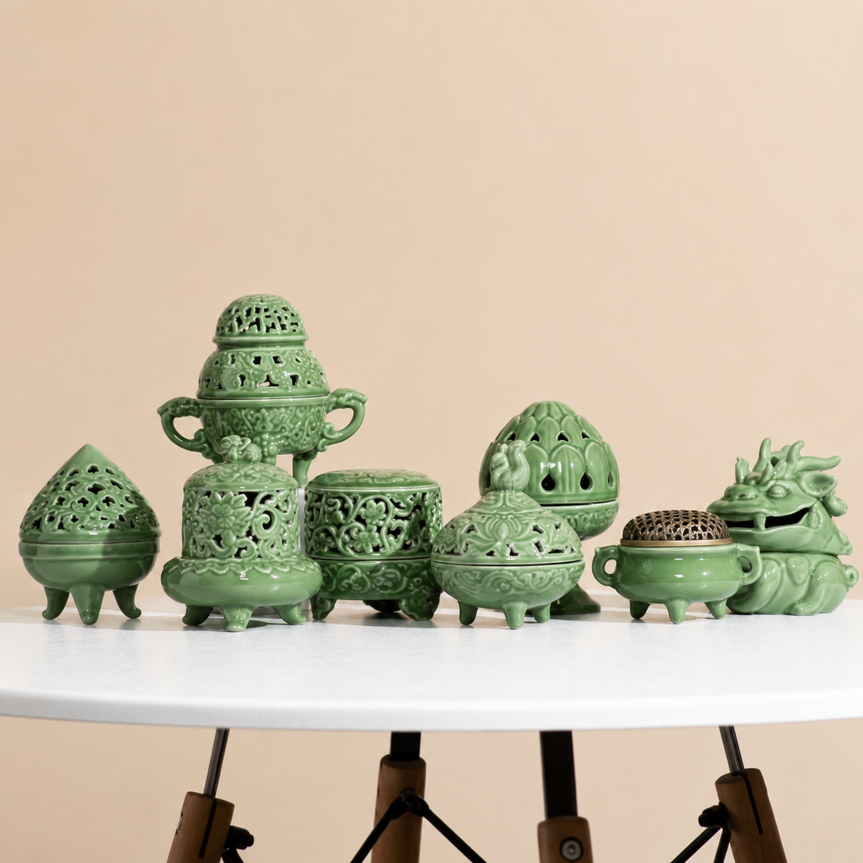 Assorted celadon green ceramic incense burner styles displayed together on a round table