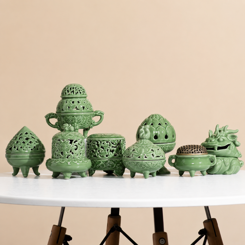 Assorted celadon green ceramic incense burner styles displayed together on a round table