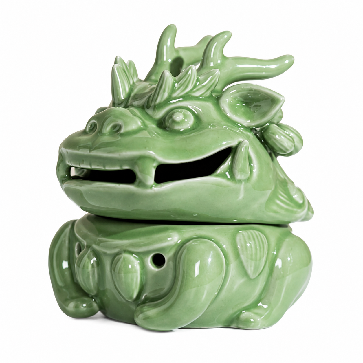 Celadon green dragon-shaped ceramic incense burner on white background