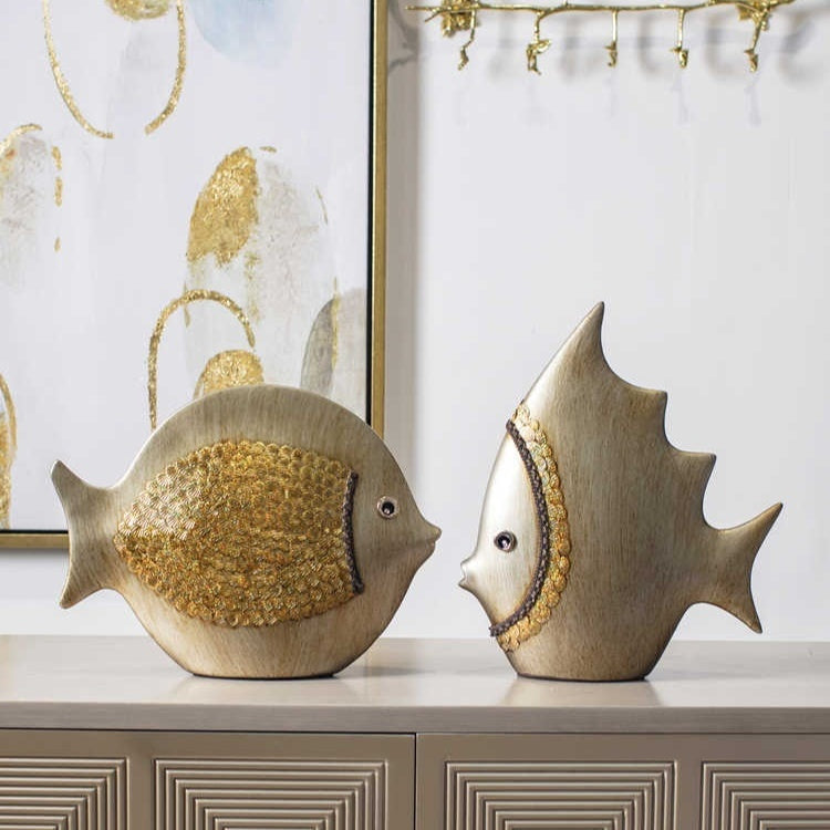 Beige ceramic fish sculptures styled as a decorative pair on a console table