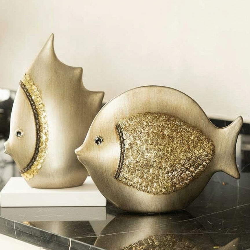 Coastal fish decor pair in ceramic displayed on a reflective tabletop