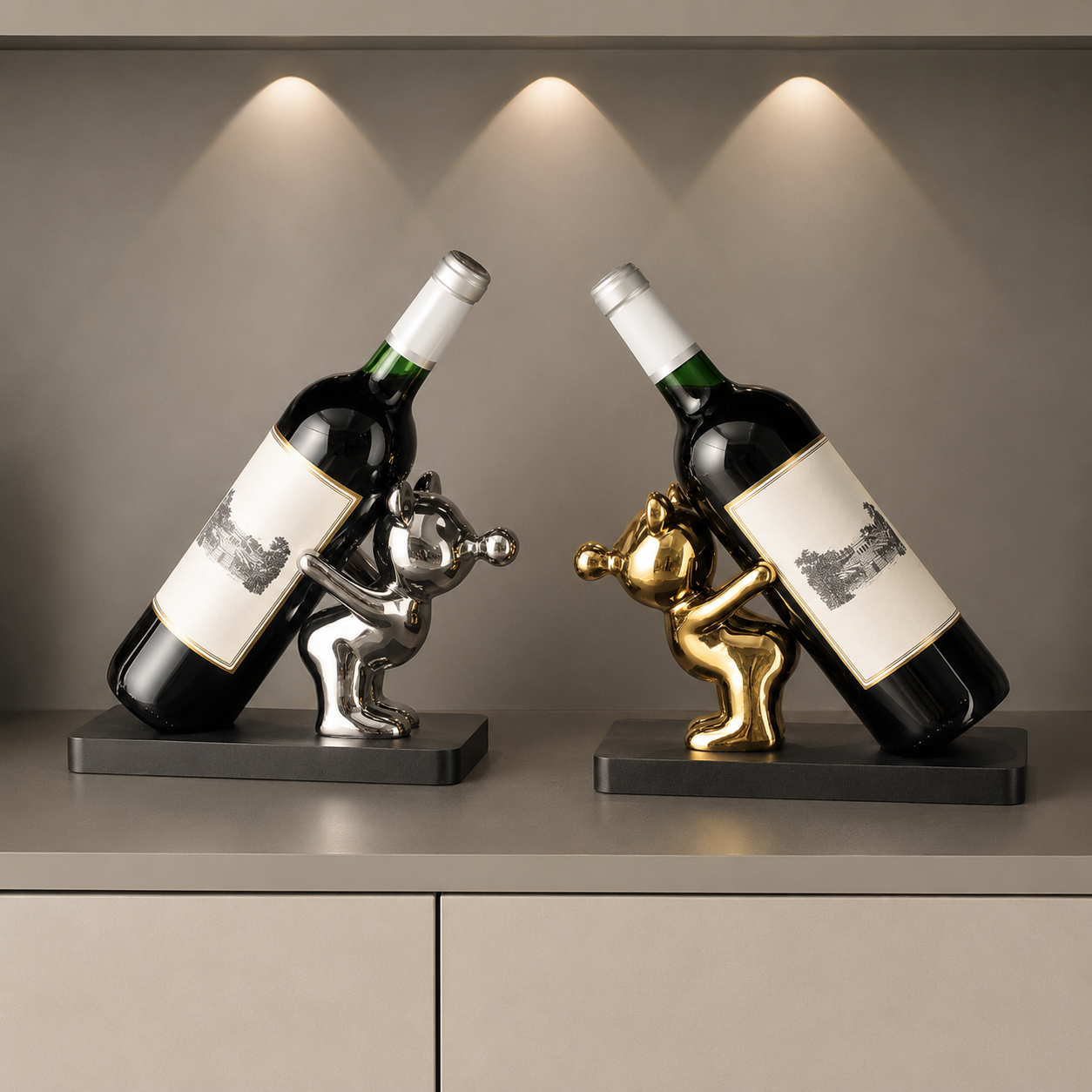 Decorative ceramic wine bottle holders in silver and gold with bottles on wood bases under warm display lights