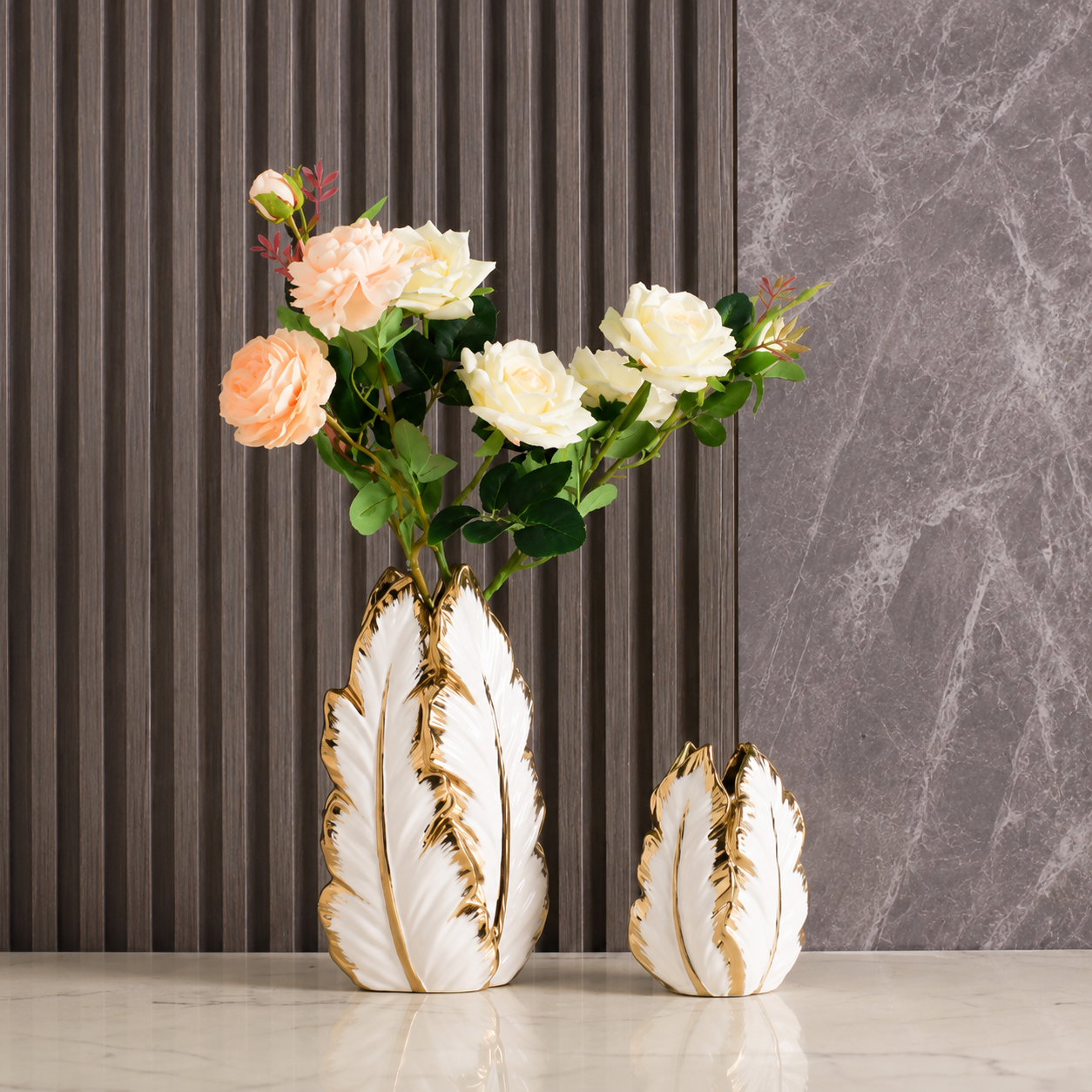 Gold electroplated plantain leaf vases styled with flowers on a console table