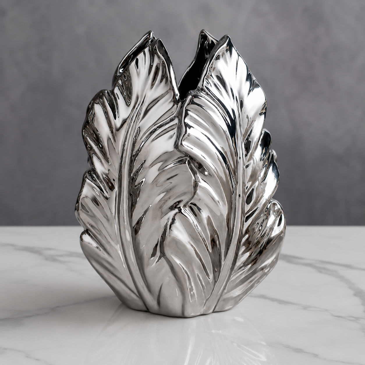 Silver electroplated ceramic plantain leaf vase with sculpted leaf texture on a tabletop