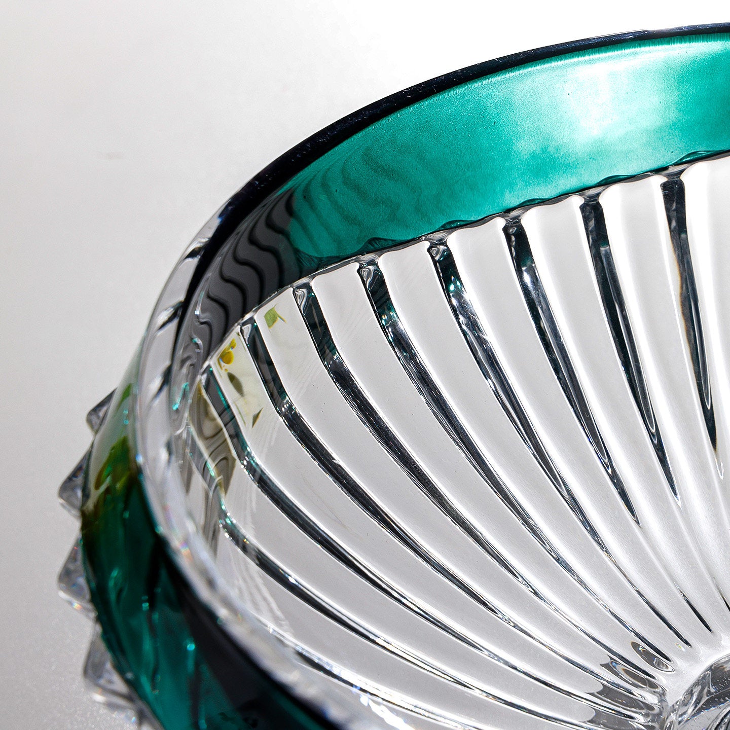 Close up of emerald green rim and clear fluted glass detailing