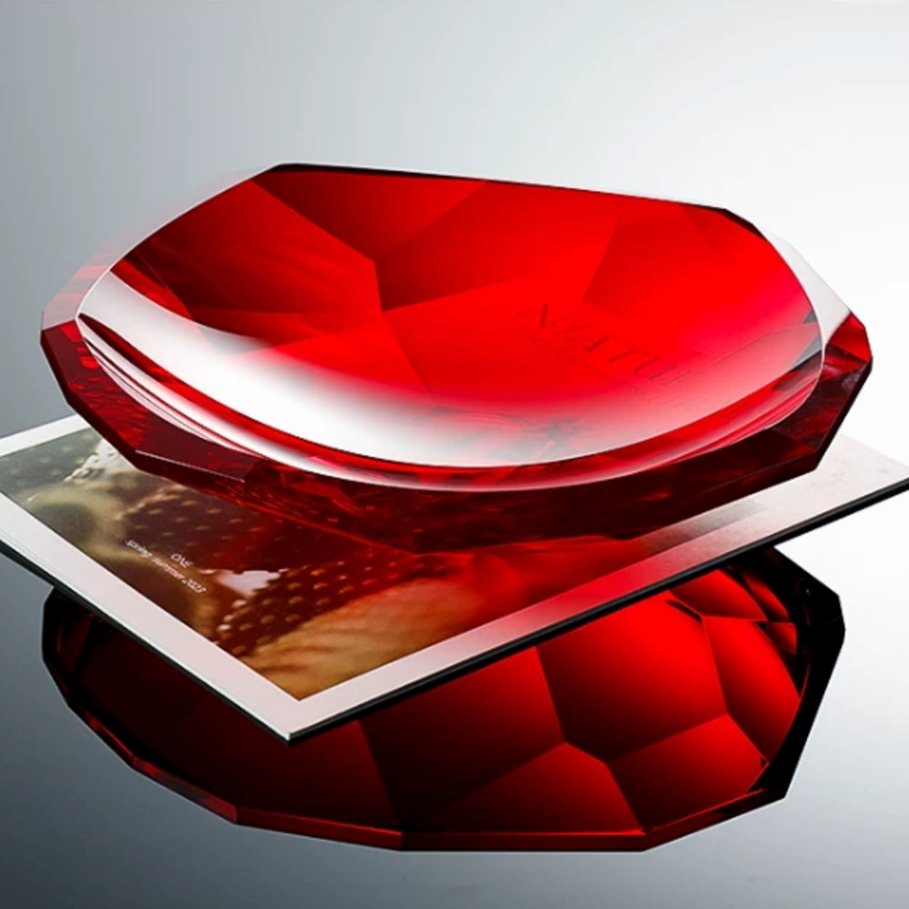 Ruby red faceted crystal glass centerpiece bowl styled on books for bold luxury decor