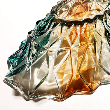 Faceted gradient glass centerpiece bowl side view showing sculptural rim and amber teal glass design