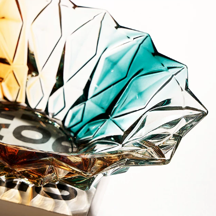 Close-up of teal amber faceted glass bowl showing geometric cut texture and flared rim