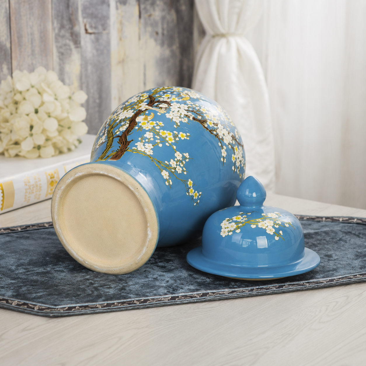 Blue floral bird ceramic ginger jar shown from the base with matching lid beside it