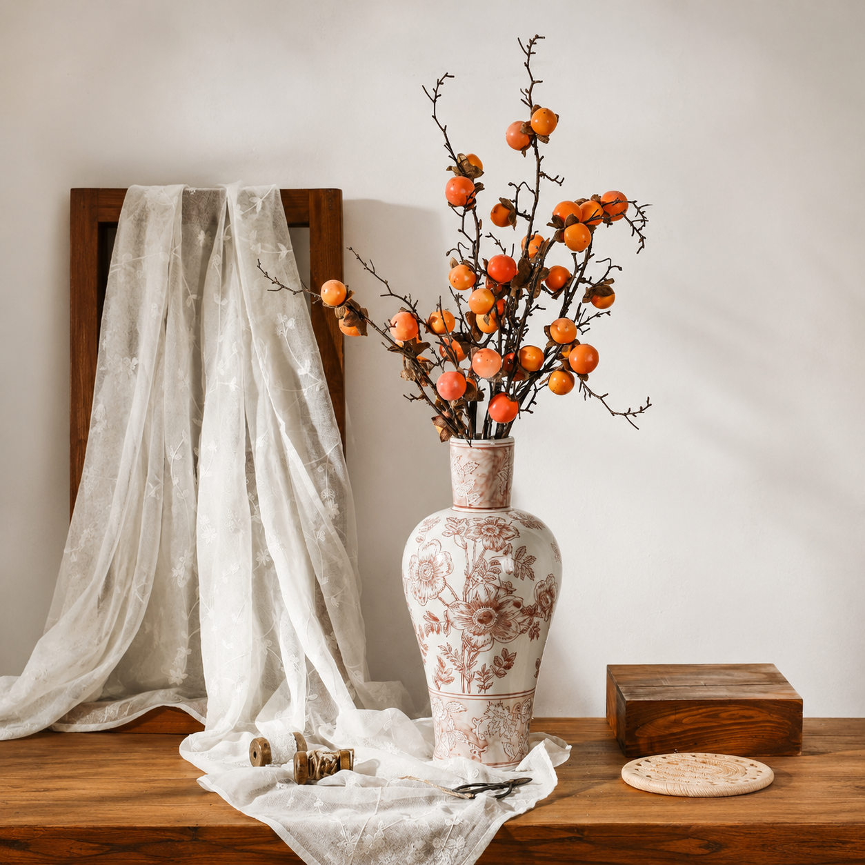 Tall brown floral ceramic vase styled with orange berry branches