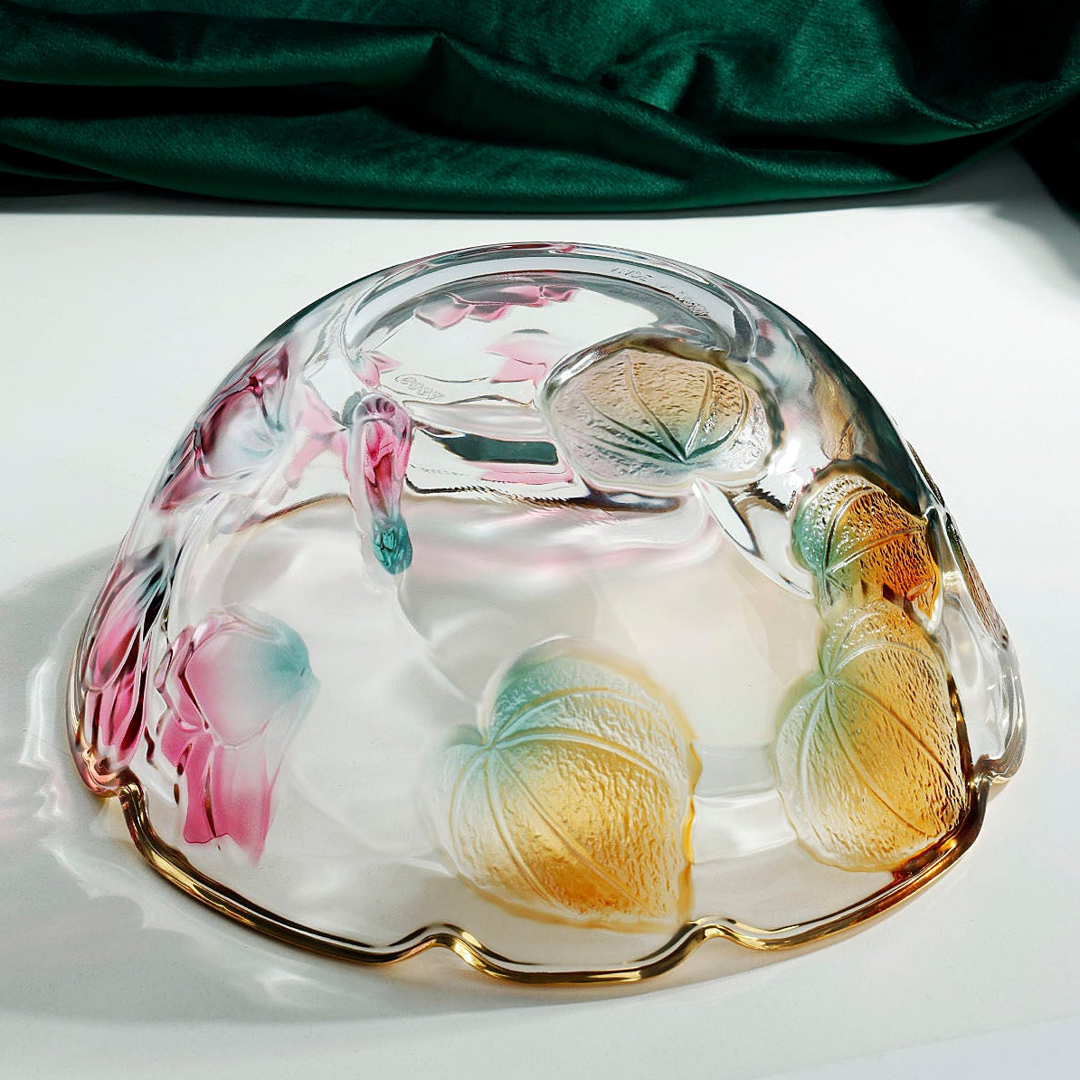Bottom view of floral embossed glass bowl showing translucent botanical detailing