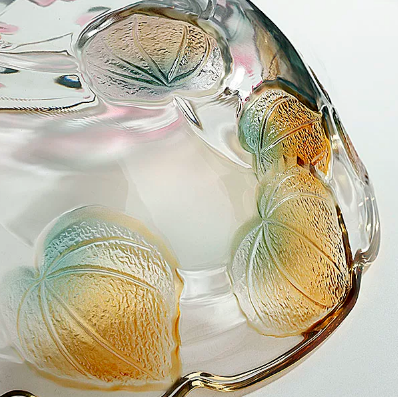 Close up of embossed floral glass bowl showing textured yellow teal and clear details