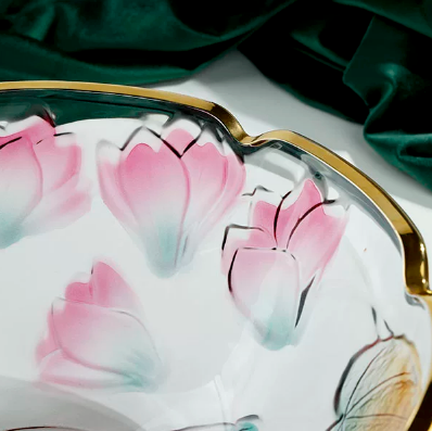 Close up of pink floral embossing and gold scalloped rim on clear glass bowl