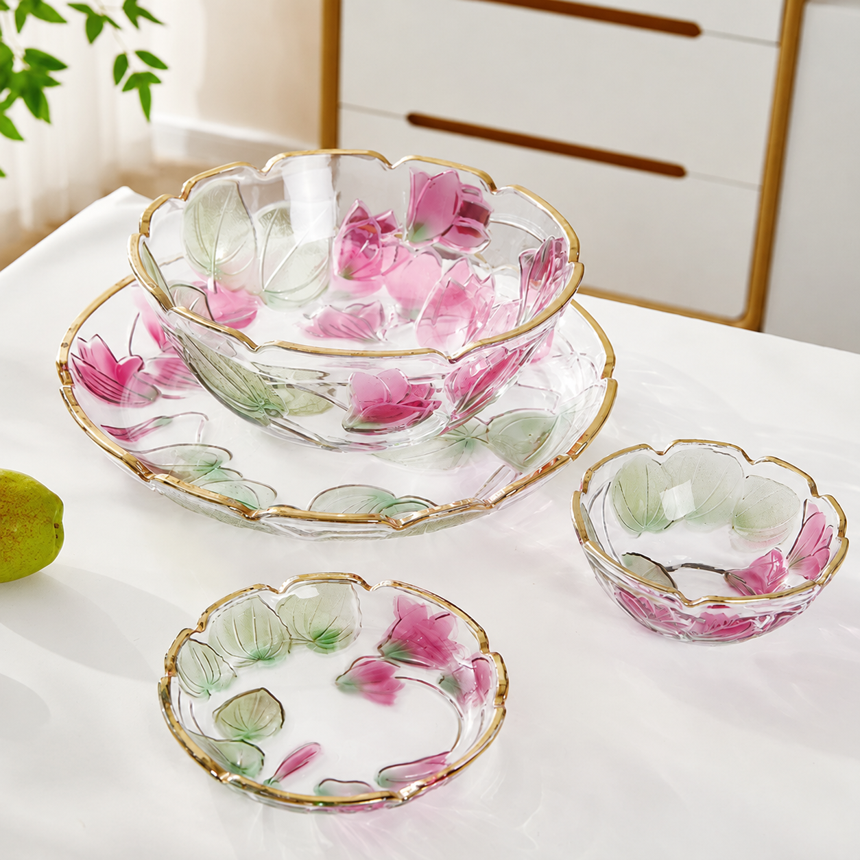 Floral embossed glass bowls and plates displayed together with pink botanical detailing and gold rims