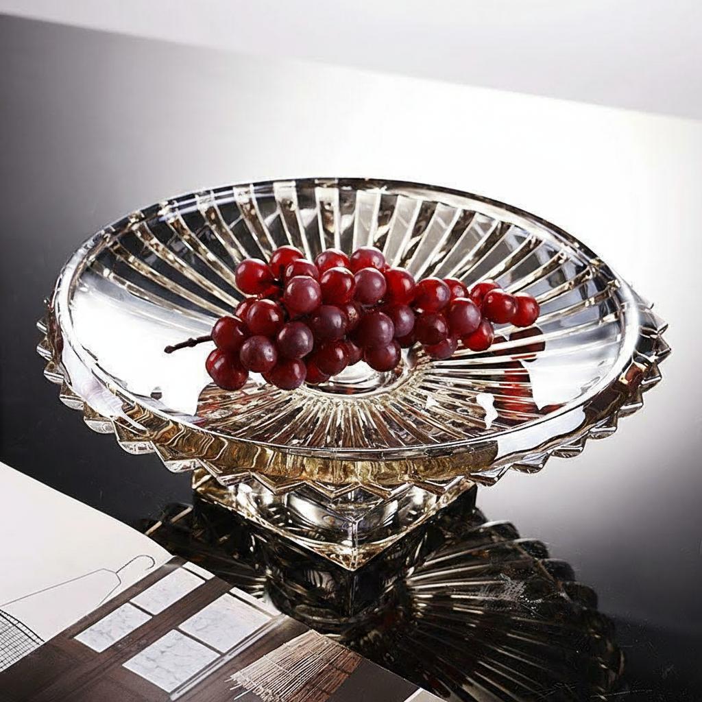Fluted glass pedestal centerpiece bowl filled with red grapes on a modern reflective table