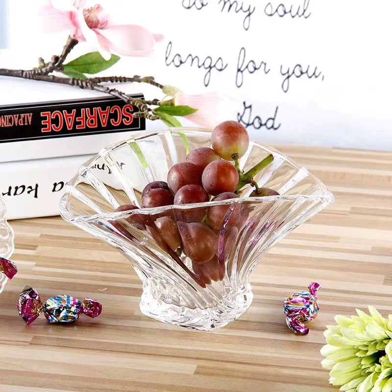 Clear fluted glass serving bowl filled with red grapes on a wooden table