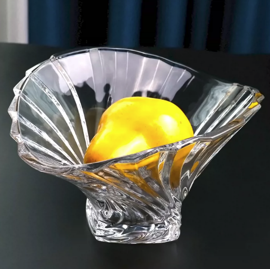 Clear fluted glass serving centerpiece bowl holding a yellow fruit