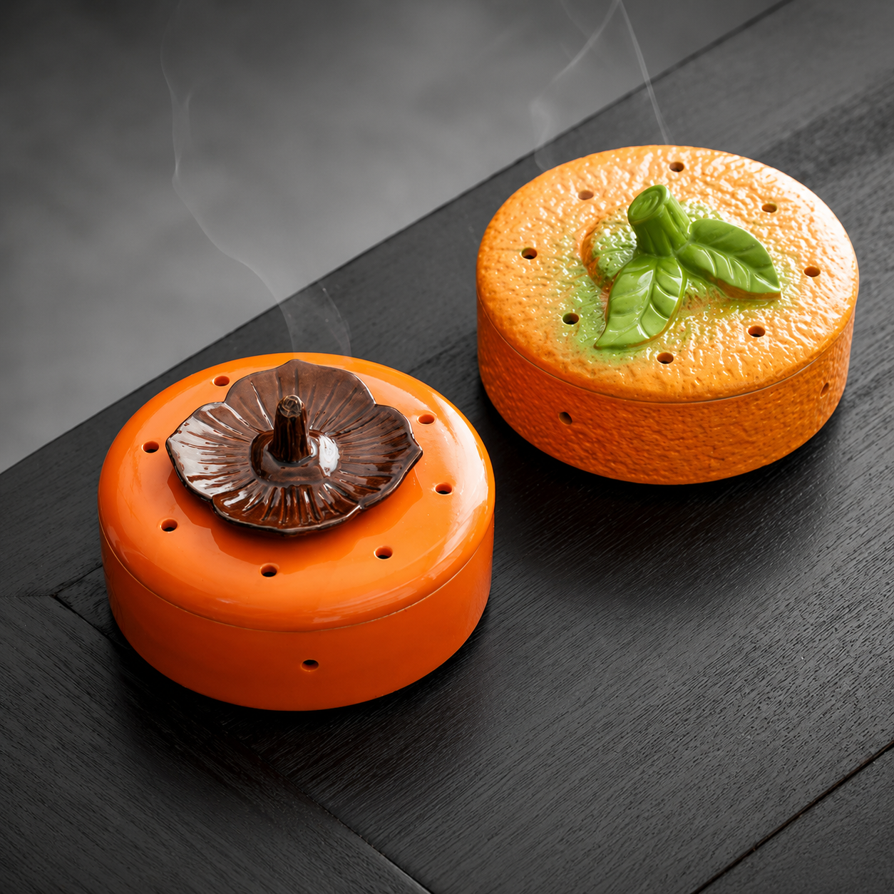 Orange and persimmon ceramic incense burners on black table for calming tea room and ritual decor