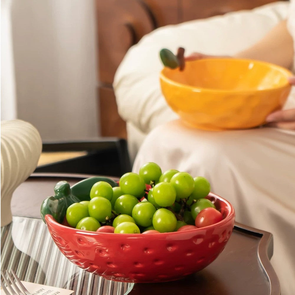 Red strawberry ceramic serving bowl styled with grapes on a tray in a cozy interior