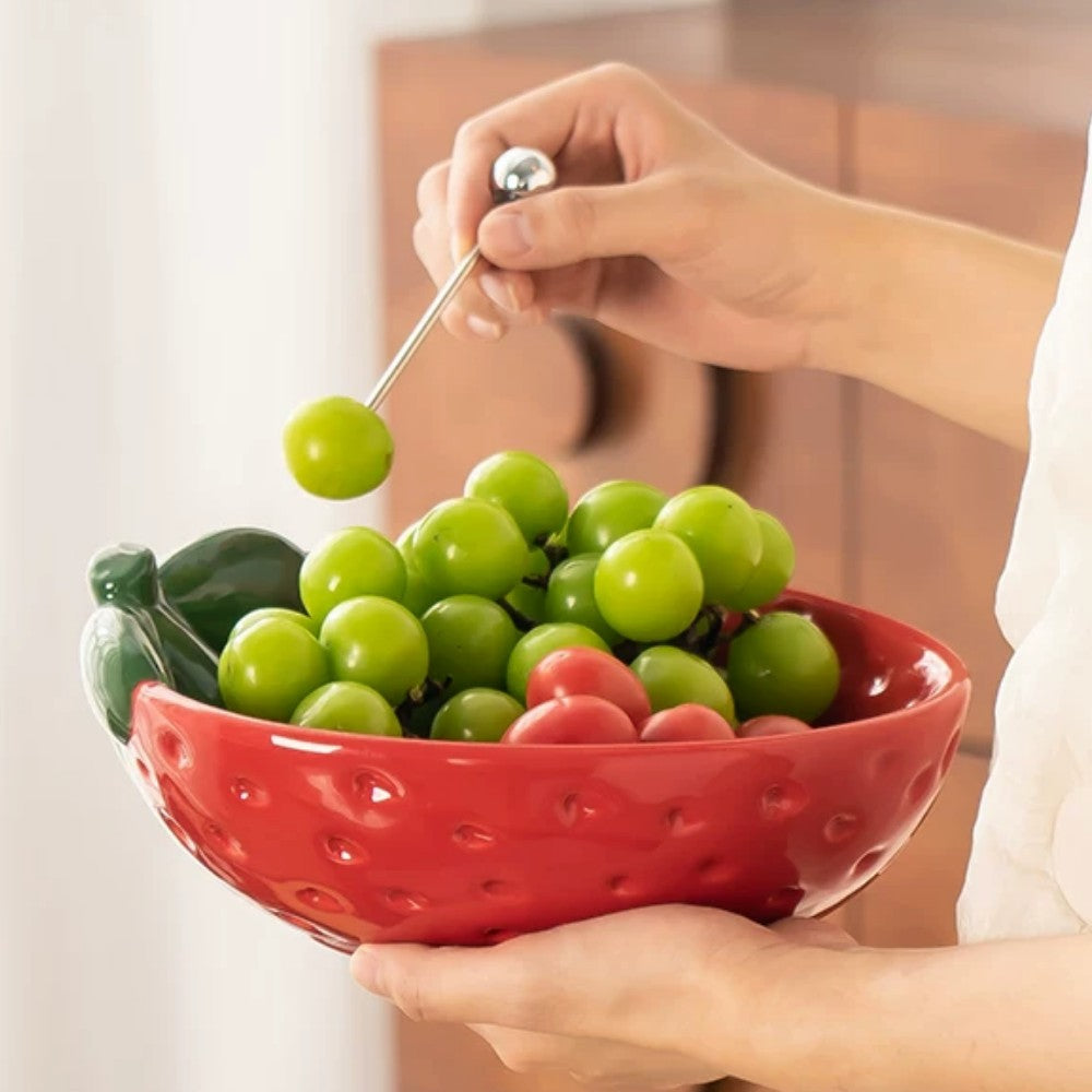 Red strawberry ceramic serving bowl styled with grapes in hand