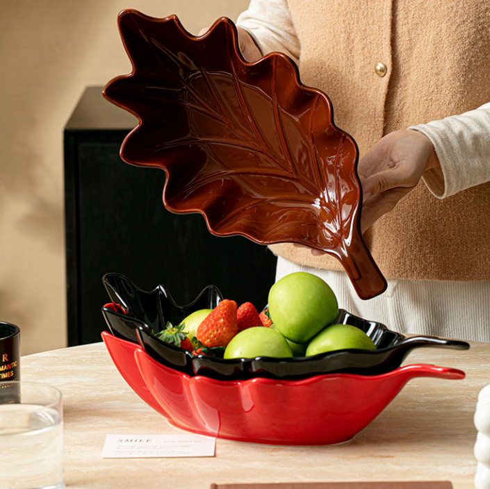 Brown black and red ceramic leaf serving bowls styled with fruit and snacks
