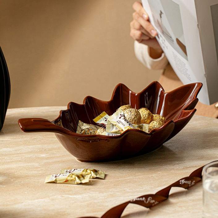 Brown glossy ceramic leaf serving bowl with nuts for coffee table styling