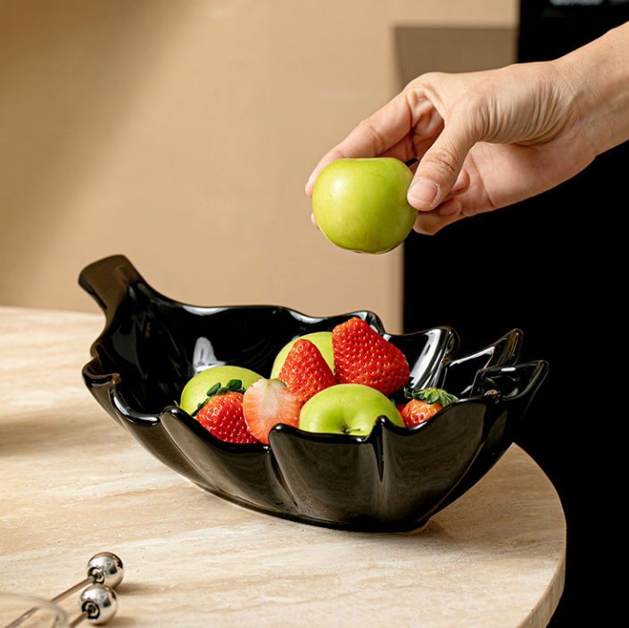 Black ceramic leaf serving bowl with apples and strawberries for modern table decor