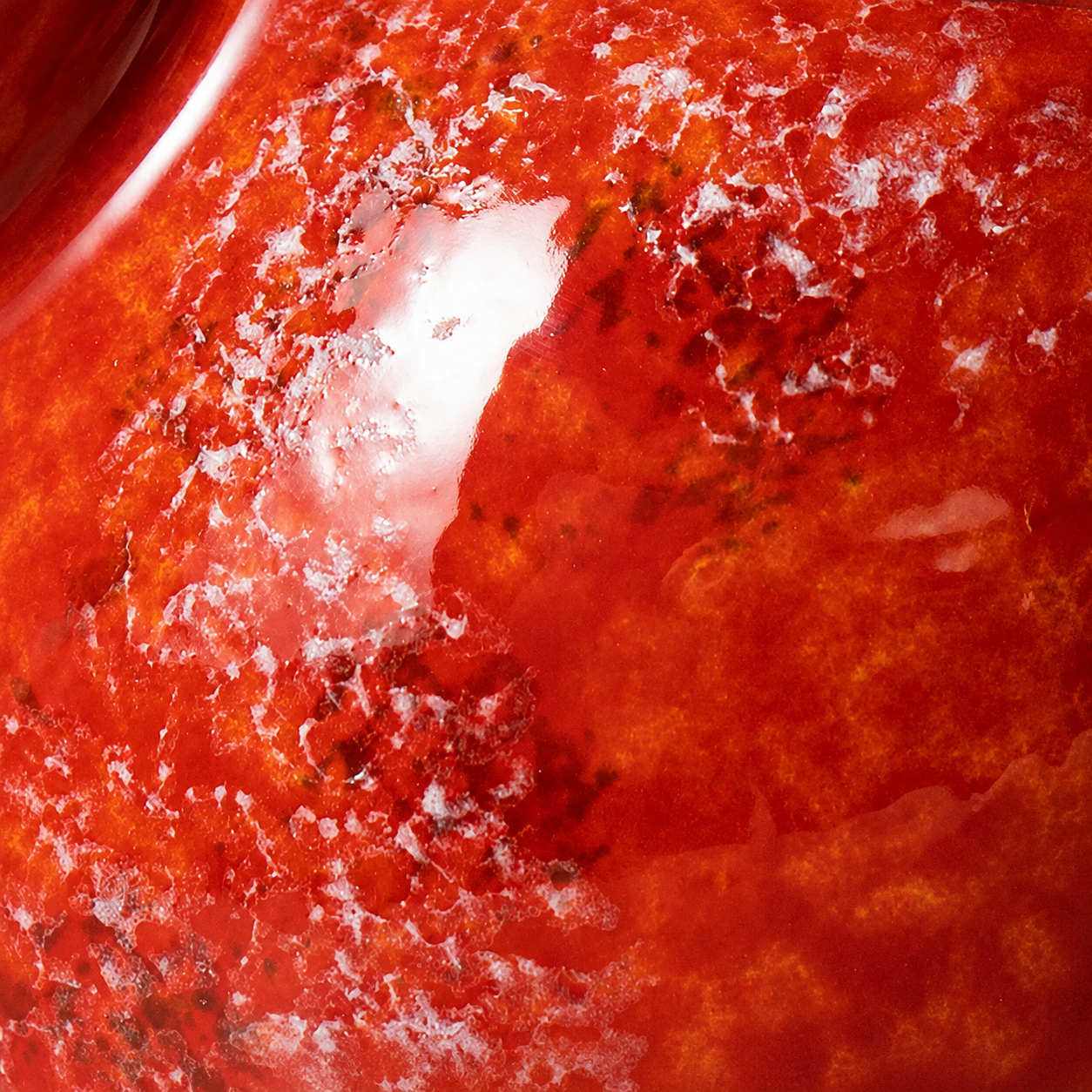 Close up of marbled orange red and white ceramic glaze