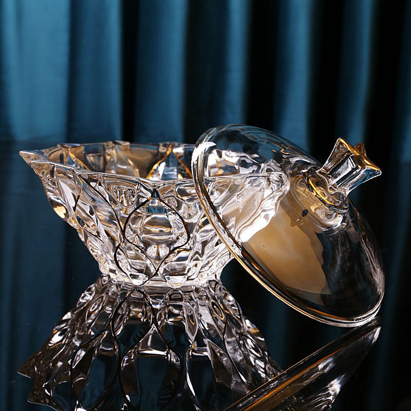 Open faceted glass bowl with matching lid displayed beside it on a reflective surface