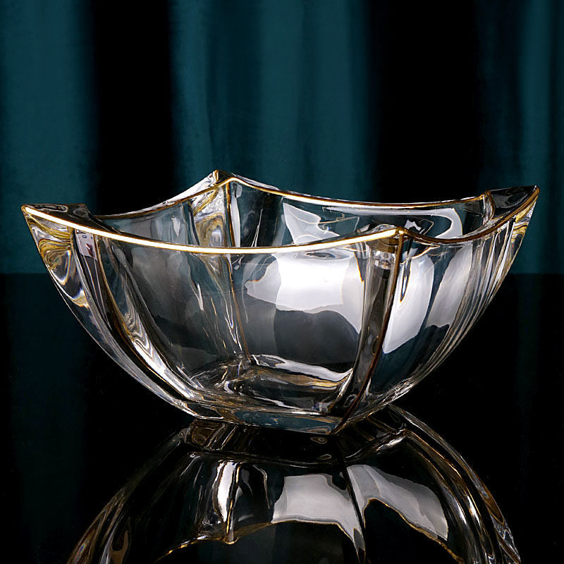 Gold rimmed wavy glass centerpiece bowl on a reflective black surface
