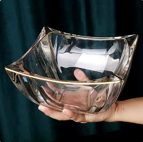 Gold rimmed wavy glass bowl held in hand for size reference